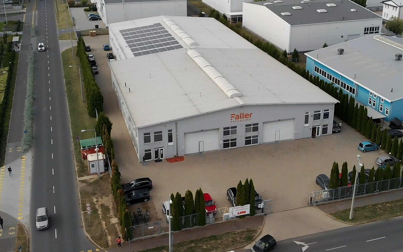 Luftaufnahme des Faller Packaging Werks in Debrecen mit Solaranlage und Firmenlogo an der Fassade
