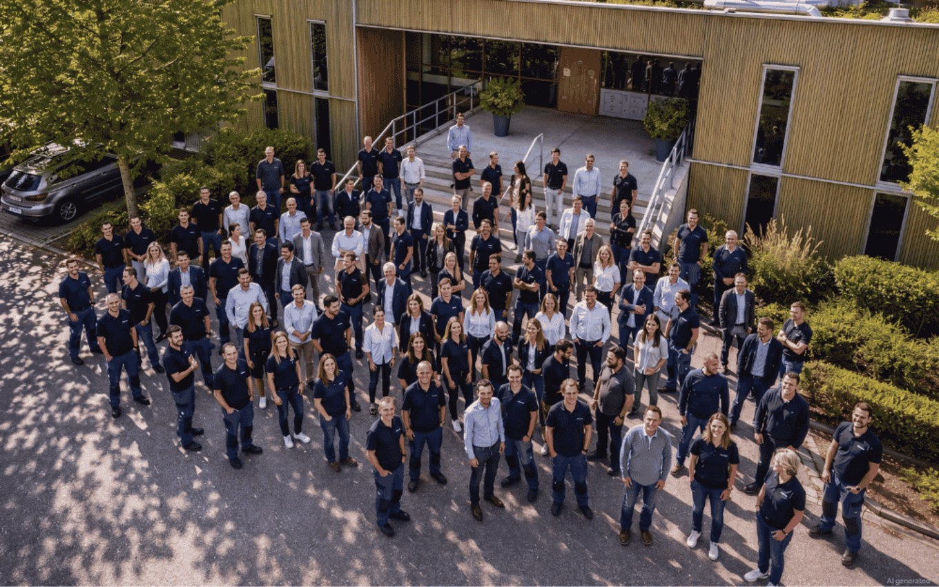 Faller Packaging employees standing in front of a Faller branch, looking optimistically into the camera.